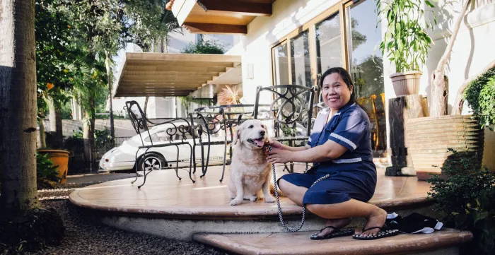 a domestic worker taking care of a white dog